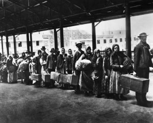 immigrati-in-attesa-a-Ellis-Island-New-York-inizio-900